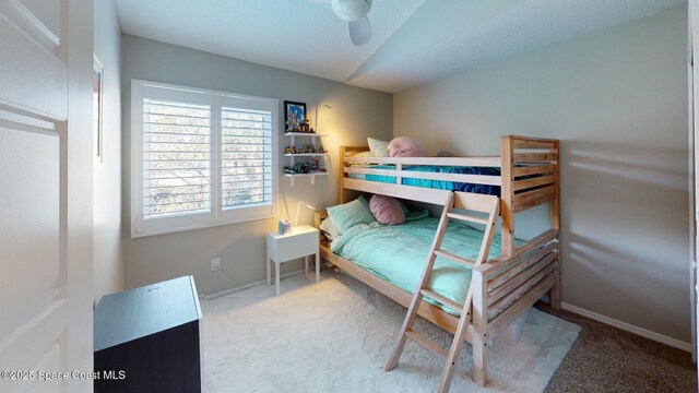 carpeted bedroom featuring baseboards and lofted ceiling