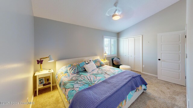 bedroom featuring a closet, baseboards, light colored carpet, and vaulted ceiling