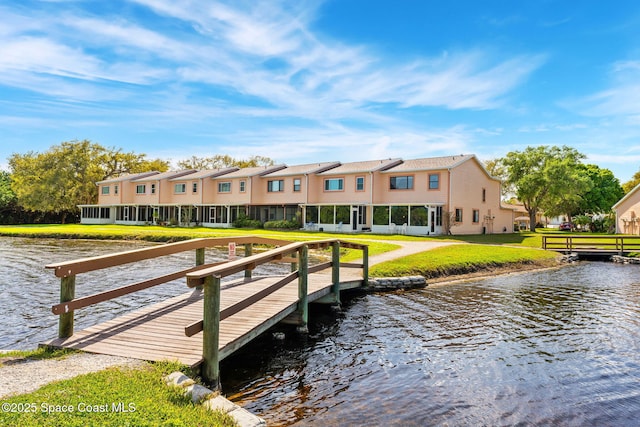 dock area featuring a lawn, a water view, and a residential view