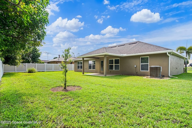 rear view of house with a yard, a patio area, and central air condition unit