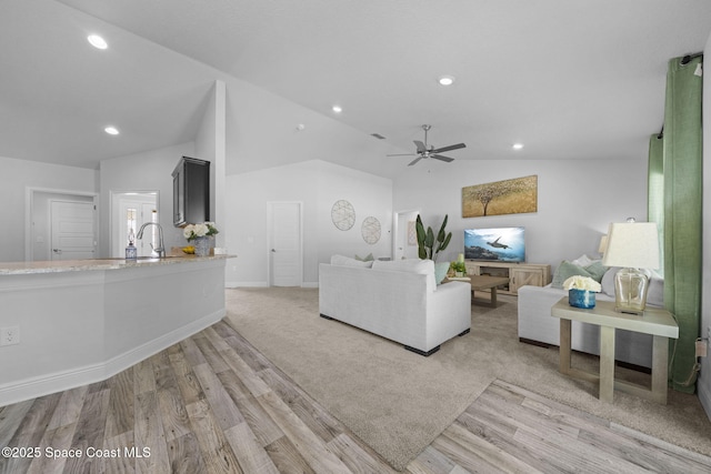 living room featuring vaulted ceiling, ceiling fan, and light hardwood / wood-style floors