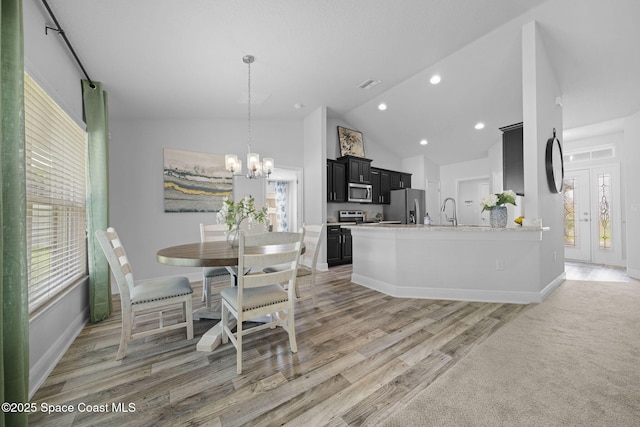 kitchen with light stone countertops, appliances with stainless steel finishes, plenty of natural light, and a chandelier