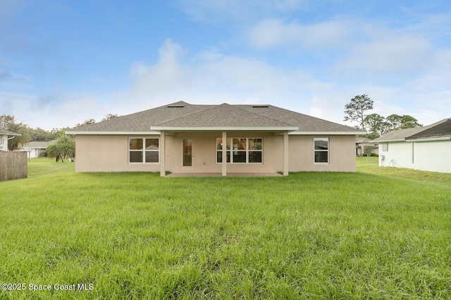 rear view of property featuring a lawn