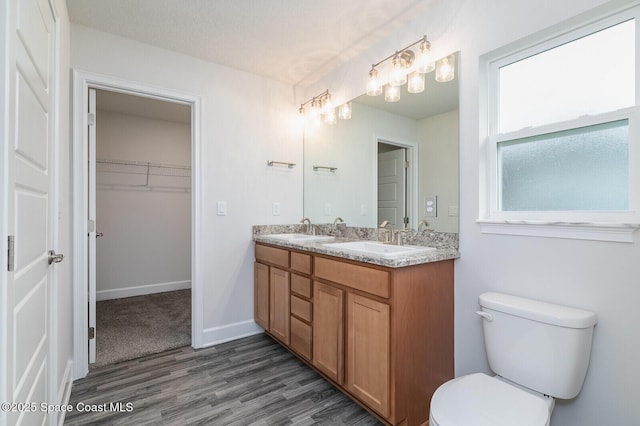 bathroom featuring hardwood / wood-style flooring, vanity, toilet, and a textured ceiling