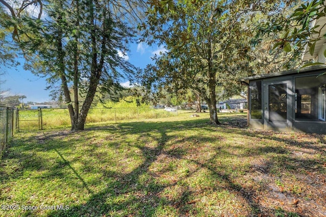 view of yard featuring a fenced backyard and a sunroom