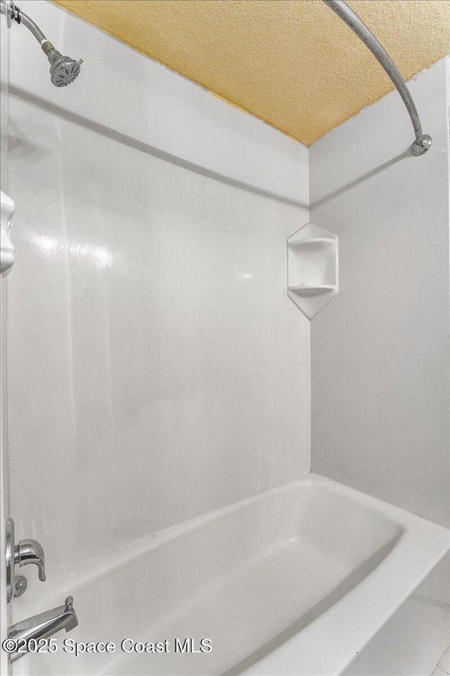 bathroom featuring a textured ceiling and shower / tub combination