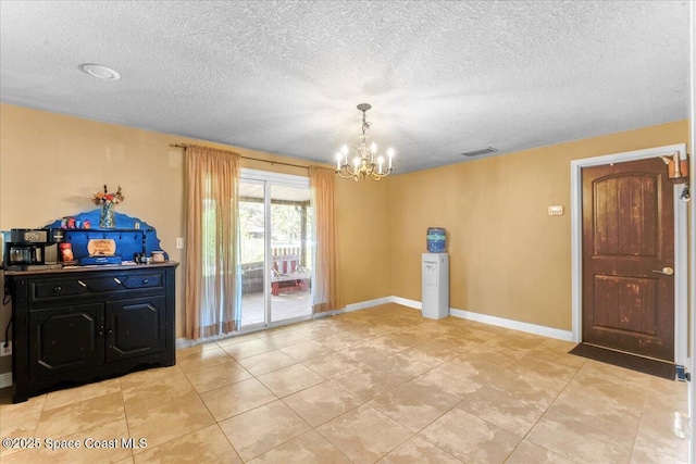 interior space featuring an inviting chandelier, baseboards, visible vents, and a textured ceiling