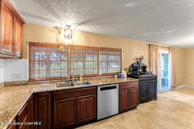 kitchen with light stone counters, dishwasher, a textured ceiling, and a sink