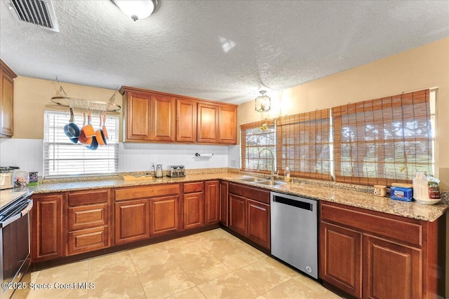 kitchen featuring stove, a sink, visible vents, stainless steel dishwasher, and brown cabinets