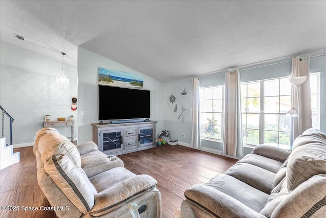 living area with lofted ceiling, a textured ceiling, visible vents, and dark wood-type flooring