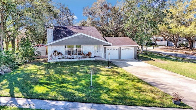 view of front of home featuring a front yard, concrete driveway, a chimney, and an attached garage