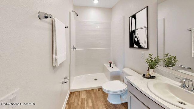 bathroom featuring walk in shower, vanity, toilet, and wood-type flooring