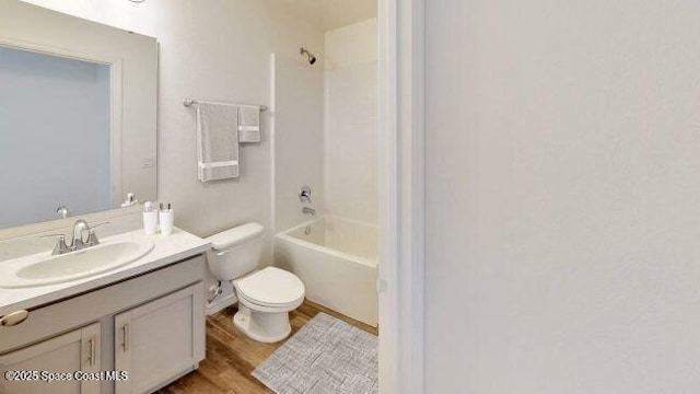 full bathroom with vanity, hardwood / wood-style flooring, tub / shower combination, and toilet