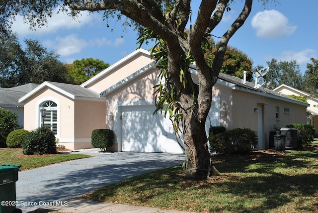 single story home with driveway, stucco siding, an attached garage, cooling unit, and a front yard