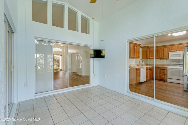 interior space featuring a sink, a high ceiling, and light tile patterned floors