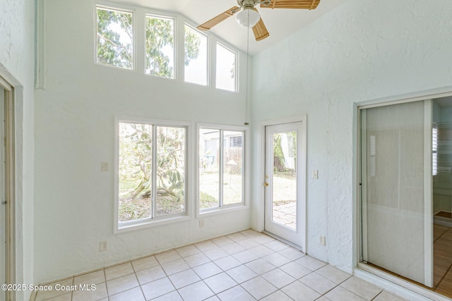 unfurnished sunroom with lofted ceiling and ceiling fan