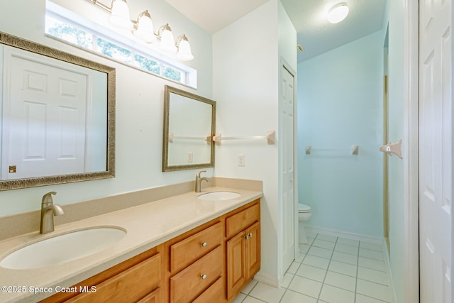 bathroom featuring tile patterned floors, a sink, toilet, and double vanity