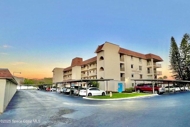 property at dusk featuring covered parking