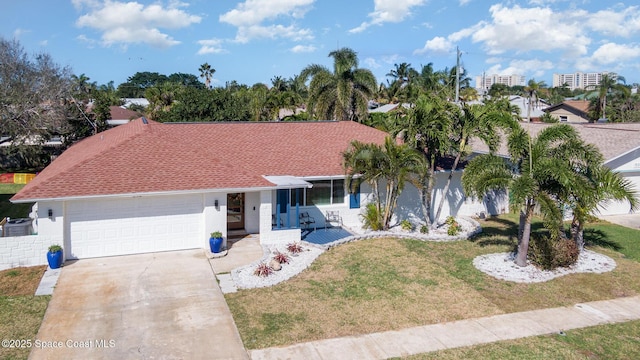 ranch-style home featuring an attached garage, driveway, roof with shingles, stucco siding, and a front yard