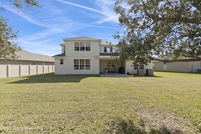 rear view of property with fence, a lawn, central AC, and stucco siding