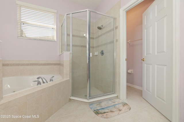 bathroom with a stall shower, tile patterned flooring, and a bath