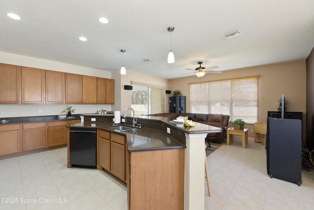 kitchen with black dishwasher, brown cabinets, hanging light fixtures, a kitchen island with sink, and a sink