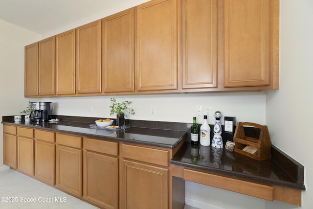 kitchen featuring dark stone counters and brown cabinetry