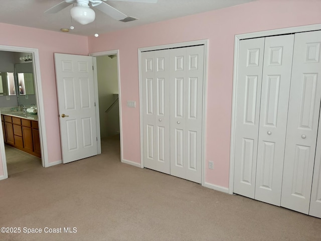 113 Wading Bird Cir SW, Palm Bay, FL 32908 - unfurnished bedroom featuring light colored carpet, two closets, baseboards, and a sink