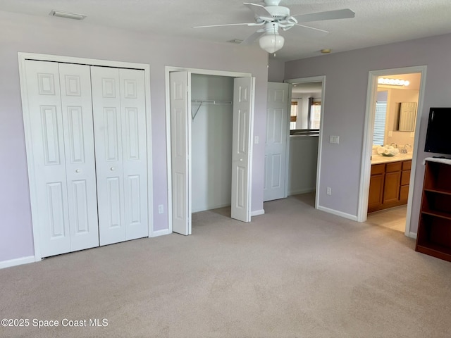 113 Wading Bird Cir SW, Palm Bay, FL 32908 - unfurnished bedroom with two closets, light colored carpet, baseboards, a ceiling fan, and ensuite bathroom