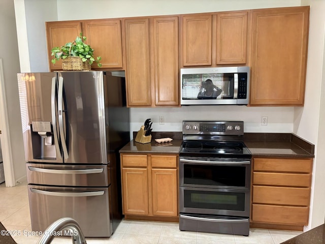 113 Wading Bird Cir SW, Palm Bay, FL 32908 - kitchen featuring stainless steel appliances, dark countertops, and light tile patterned flooring