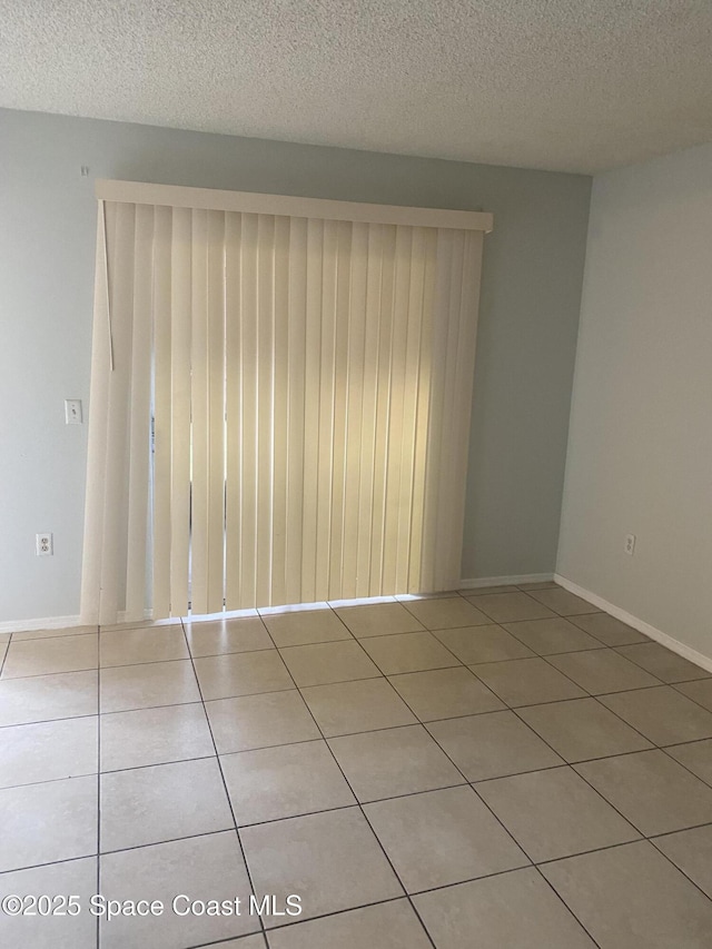 tiled spare room with a textured ceiling