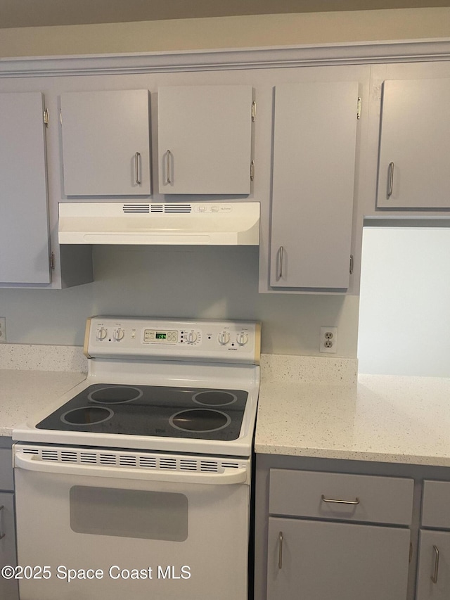 kitchen with gray cabinets, light stone countertops, and electric range