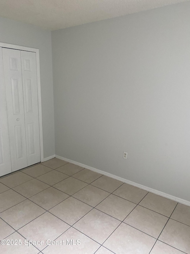 unfurnished bedroom featuring a closet and light tile patterned floors