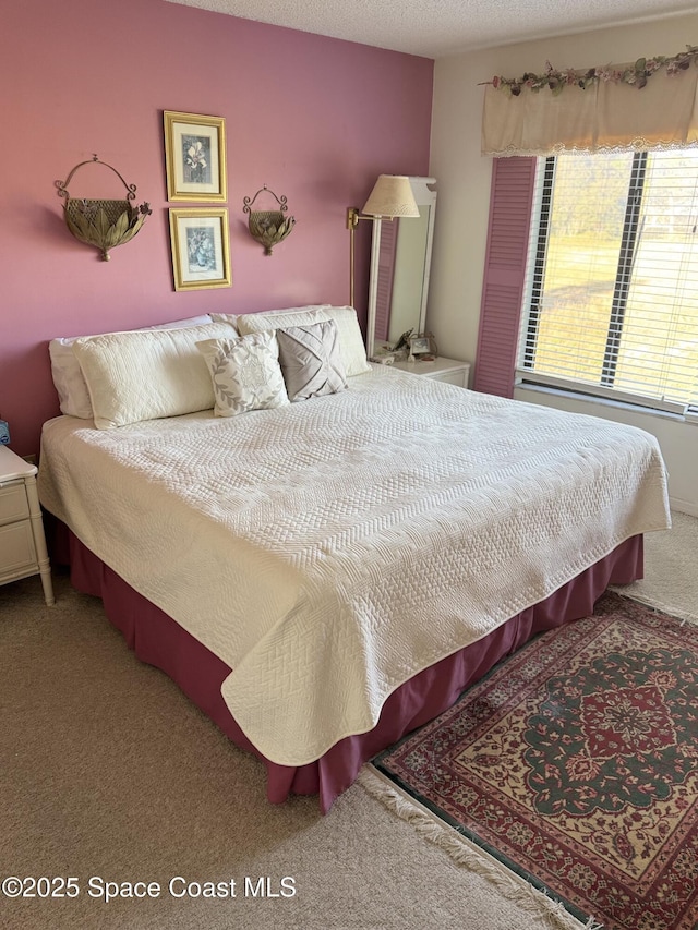 bedroom featuring carpet and a textured ceiling