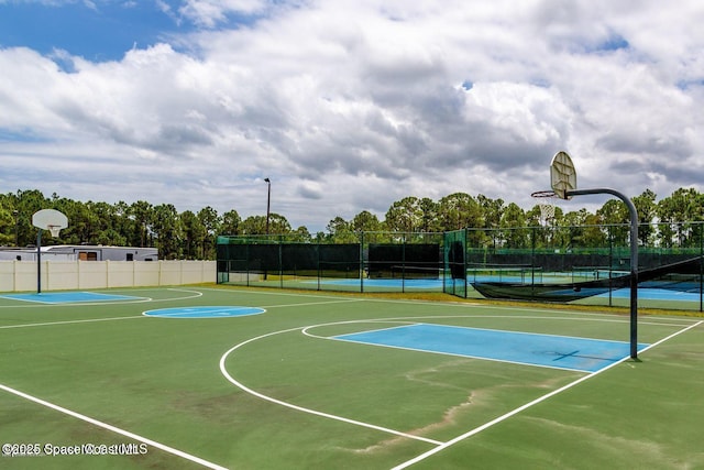 view of sport court with a tennis court, community basketball court, and fence