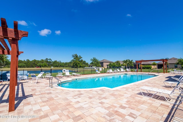 pool with a water view, a patio area, fence, and a pergola