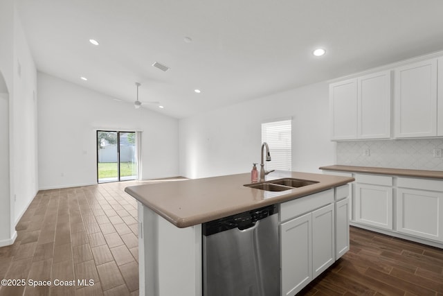 kitchen featuring dishwasher, a kitchen island with sink, a sink, and white cabinetry