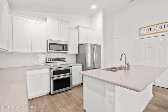 kitchen featuring light countertops, appliances with stainless steel finishes, a sink, and white cabinetry