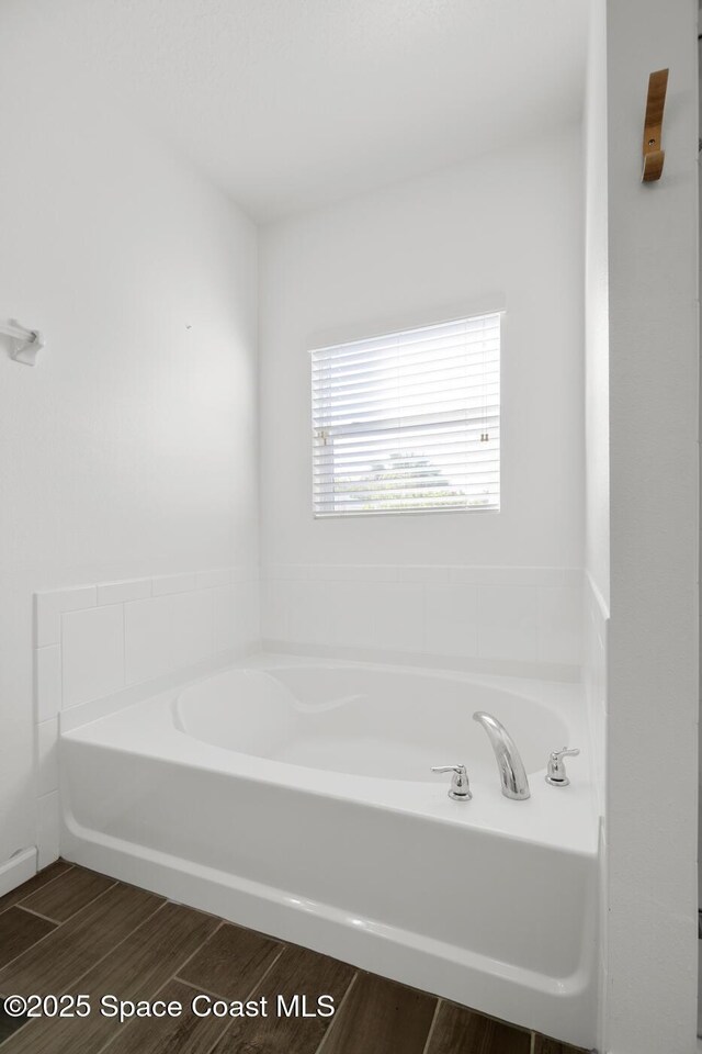 full bath with wood finished floors and a bath