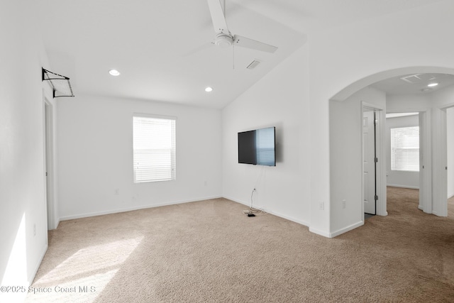 spare room featuring arched walkways, light carpet, lofted ceiling, and recessed lighting