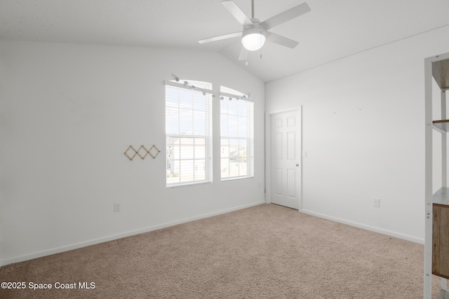 spare room featuring lofted ceiling, carpet, baseboards, and ceiling fan