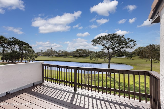 deck with a water view and a yard