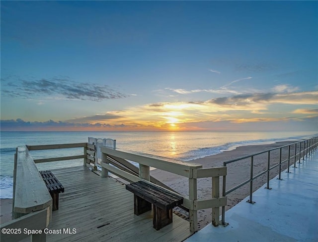 dock area with a beach view and a water view