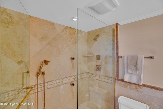 full bathroom featuring visible vents, toilet, tile walls, crown molding, and a walk in shower