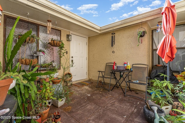 view of exterior entry with a patio