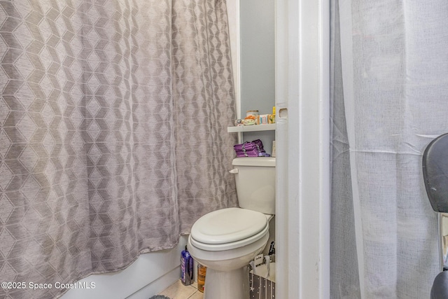 bathroom featuring shower / tub combo with curtain, toilet, and tile patterned flooring