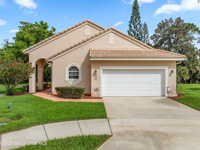 mediterranean / spanish-style home with driveway, stucco siding, an attached garage, and a front yard