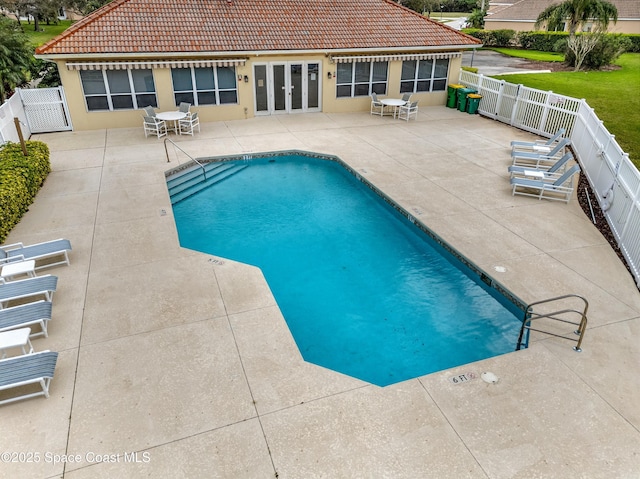 community pool with a patio and fence