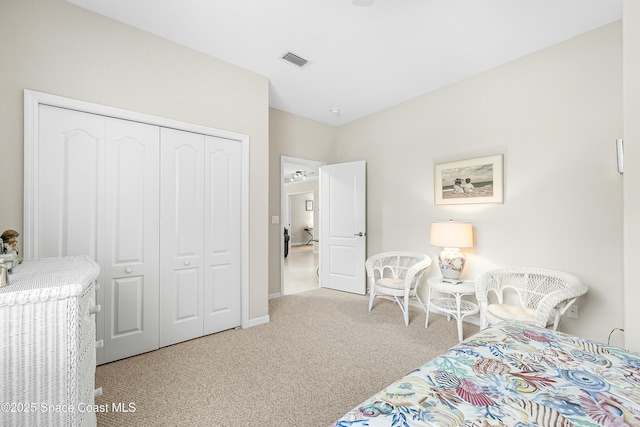 bedroom featuring a closet, visible vents, and light carpet