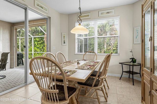 dining area featuring a healthy amount of sunlight, light tile patterned floors, and baseboards